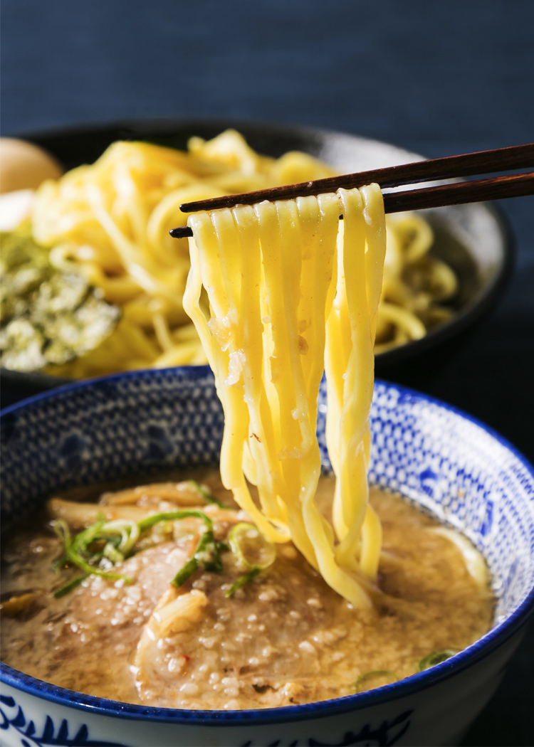 平麺つけそばを箸で持ち上げている写真