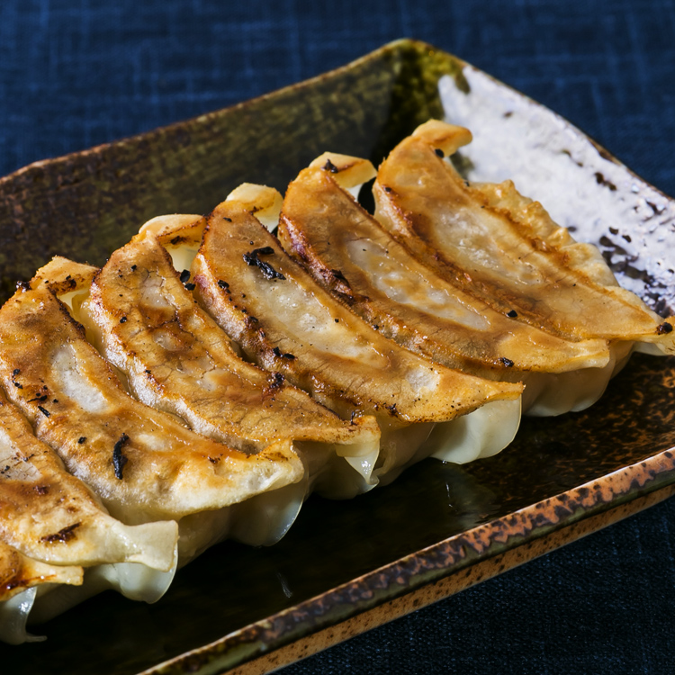 表面がこんがり焼けたきつね色の餃子の写真